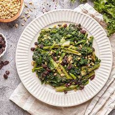 a white plate topped with broccoli and raisins next to other foods