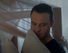 a man is hiding behind some pillows