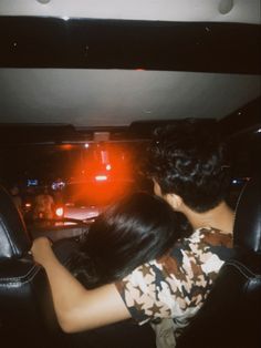 a man and woman sitting in the back of a car with their arms around each other