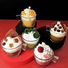 four desserts in glass bowls on a red table