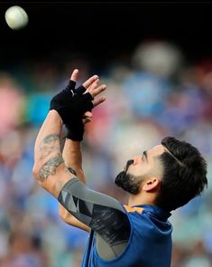 a baseball player catching a ball with his glove and arm in the air as he prepares to catch it