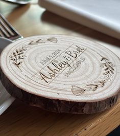 a personalized wooden plate on a table next to a fork and knife with the names of two people