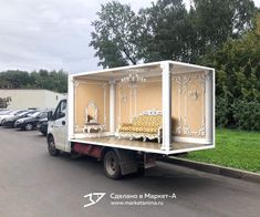 a truck with a couch in the back is parked on the side of the road