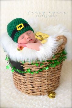 a newborn baby wearing a st patrick's day hat and sleeping in a basket