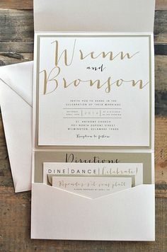 the wedding stationery is displayed on top of two envelopes and one has a gold foil