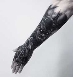 a man's arm with a black and white tattoo design on the left hand