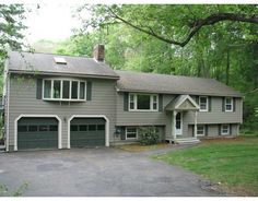 a large house with two garages in the driveway