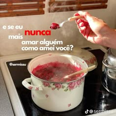 a person is spooning some food out of a pot on the stove with a spoon