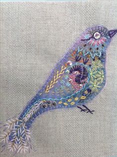 a small blue bird sitting on top of a piece of cloth