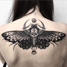 a woman's back with a butterfly tattoo on it