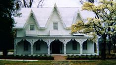 a large white house sitting in the middle of a park