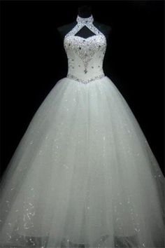 a white wedding dress on display in the dark