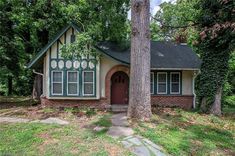 a small house in the middle of a wooded area with trees and grass around it