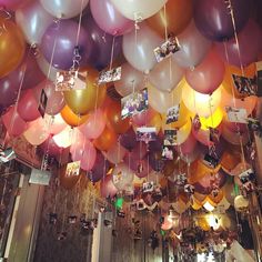 many balloons are hanging from the ceiling with pictures on them