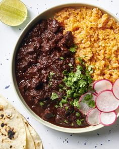 a bowl filled with rice and beans next to sliced radishes