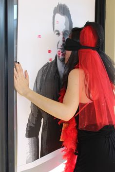 a man and woman dressed up in costume standing next to each other near a poster