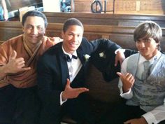 three men in tuxedos posing for the camera with one pointing at the camera