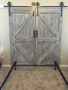 an old barn door with black hardware is shown in this bedroom setting, and it has carpeted flooring on both sides