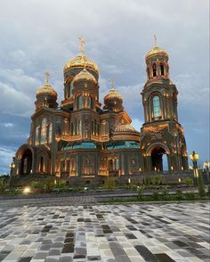 a large building with two towers and gold domes on it's sides at night