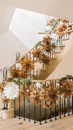 a staircase decorated with paper flowers and greenery for the holiday season is seen in this image