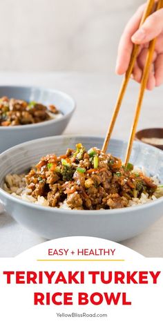 two bowls filled with rice, meat and vegetables on top of a white table next to chopsticks