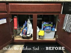 the kitchen cabinet door is open to reveal cleaning products and other items in its storage compartment