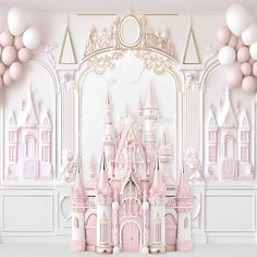 a pink castle is surrounded by balloons in front of a white wall with gold trim