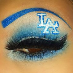 a woman with blue and white makeup has her eyes painted like the university of texas logo