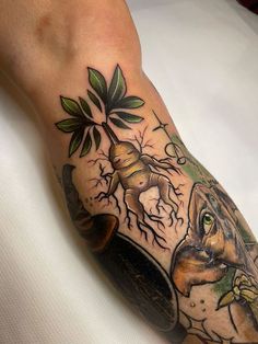 a man's arm with an animal and plant tattoo on it, while he is sitting down