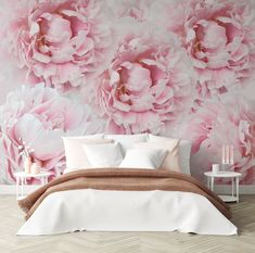 a large pink flowered wall mural in a bedroom with white bedding and pillows