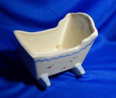 a white ceramic baby bath tub sitting on a blue cloth