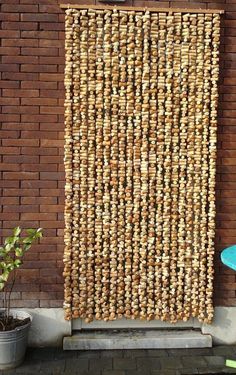 a wall made out of wine corks on the side of a brick building next to a blue chair