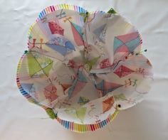 a paper plate with kites on it sitting on top of a white tablecloth