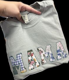 someone is holding up a t - shirt with the word mama on it