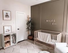 Boy nursery with personalized wooden name sign above crib Nursery Wall Board And Batten, Cream Color Nursery, Nursery Brown Walls, Taupe Accent Wall Nursery, Accent Wall Baby Boy Nursery, Nursery Wood Paneling, Brown Accent Wall Nursery, Half Wall Paneling Ideas Nursery, Shiplap Accent Wall Nursery