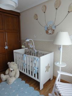 a baby's room with a crib, rocking chair and teddy bear