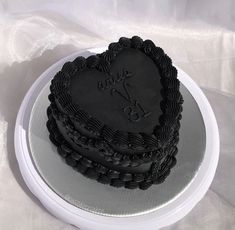 a heart - shaped cake on a plate with the word love spelled in black frosting