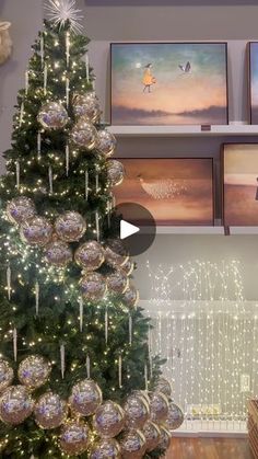 a christmas tree in front of pictures on the wall with lights and ornaments around it