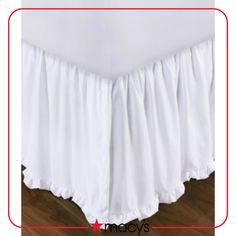 white bed skirt with ruffled edges on wooden floor