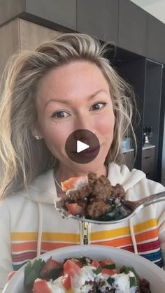 a woman holding a plate with food on it