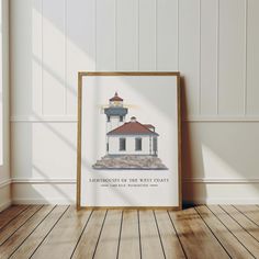 a framed photograph of a lighthouse on the wall next to a wooden floor and white walls