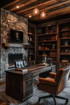 a home office with stone fireplace and built - in bookcases, leather chair, and desk