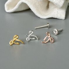 three pairs of earrings sitting on top of a table