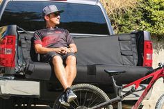 a man sitting in the back of a truck with his bike