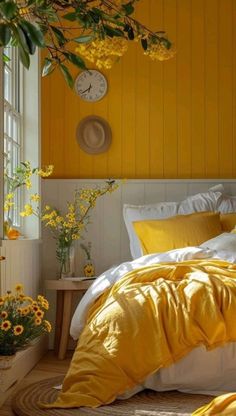 a bed with yellow sheets and pillows in a bedroom next to a clock on the wall