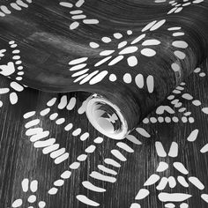 a black and white photo of an artistic wallpaper design with leaves on the floor