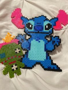 two pieces of perler bead art depicting stitching characters, one blue and the other green