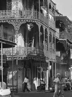 an old black and white photo of people walking down the street in front of buildings