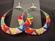 Very bright and colorful hand beaded hoop earrings. You can dress up or down with this pair. They are light weight so are easy to wear for an entire day. Trendy Handmade Hoop Beaded Earrings, Multicolor Circular Summer Earrings, Multicolor Hoop Earrings For Summer, Multicolor Round Earrings For Summer, Bohemian Spring Jewelry With Colorful Beads, Spring Bohemian Jewelry With Colorful Beads, Colorful Hoop Earrings For Summer, Multicolor Hoop Earrings For Summer Festival, Colorful Hoop Summer Earrings