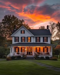 a large white house sitting on top of a lush green field under a cloudy sky